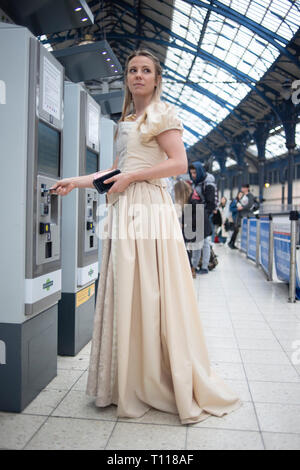 Une jeune femme blanche recueille son billet de train à partir d'un distributeur de billets à la gare de Brighton. Banque D'Images