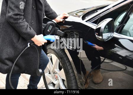 Femme de brancher sur jaguar électrique résidentielle Banque D'Images