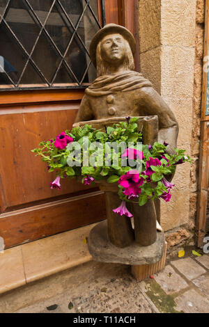 Figurine intéressante et une décoration florale en porte-à-porte dans une rue étroite et tortueuse de La Canée, Crète, Grèce Banque D'Images