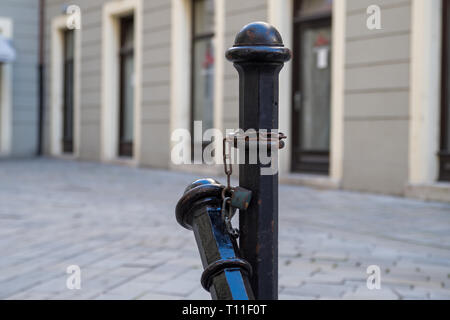 Un bollard en vieille ville de Bratislava qui est enchaînée et cadenassée à un autre point fixe, penché au-dessus Banque D'Images