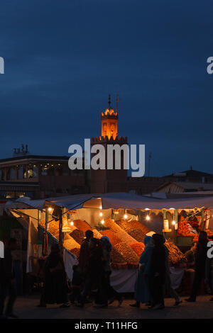 Marché de nuit dans la région de Marrakech minaret illuminé montrant tour et produire de cale Banque D'Images