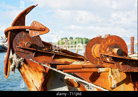 Gros plan de la proue avec une ancre rouillée et autres pièces métalliques d'un vieux navire négligé à Muelle Loney Port à Ilo-Ilo City, Philippines Banque D'Images