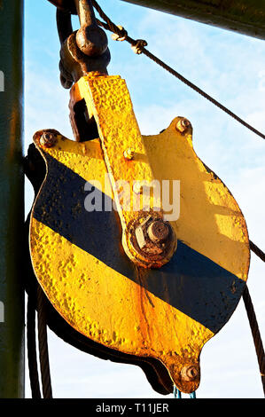 Close-up d'une vieille poulie rouillée, roue, peint en jaune et noir, couleurs d'avertissement sur un bateau entre les îles aux Philippines Banque D'Images