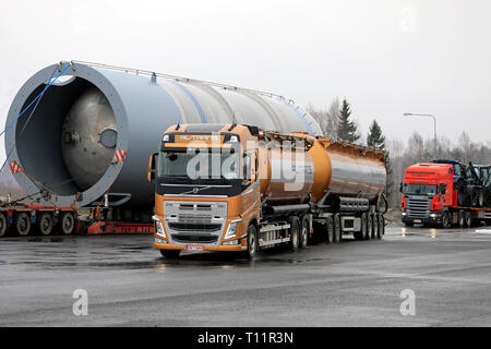 Forssa, Finlande - 16 mars 2019 : le camion Volvo FH 500 RL-Trans et la remorque à 6 essieux quittent la butée du chariot avec une charge surdimensionnée stationnée sur le fond. Banque D'Images