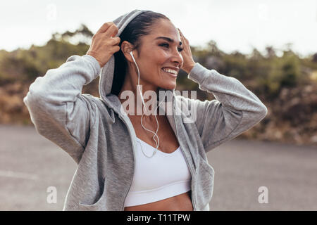 Fitness Femme portant un t-shirt la marche à l'extérieur. Female sur tôt le matin à pied. Banque D'Images