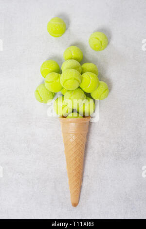 Cornet de crème glacée avec balle de tennis sur fond blanc. Concept alimentaire minimal Banque D'Images