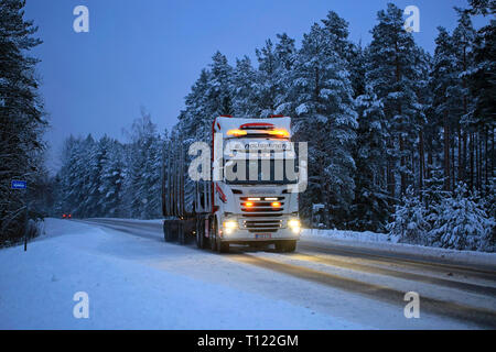 Salo, Finlande - le 25 janvier 2019 : Scania R520 E de grumier Nousiainen s'allume une route de campagne à l'heure bleue de l'hiver au crépuscule. Banque D'Images