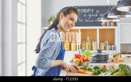 Une jeune femme prépare la nourriture dans la cuisine. Des aliments sains - vege Banque D'Images