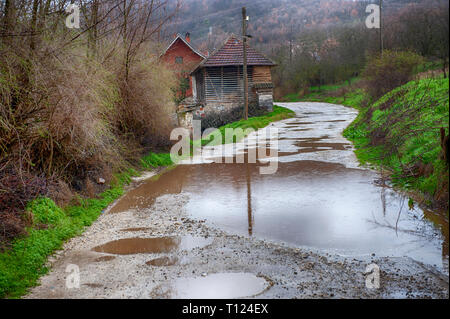 Route endommagée, fissurée épée d'asphalte avec cuvettes et les taches. Très mauvaise route asphaltée à gros trous. La construction de routes. La technologie terrible De nombreux Banque D'Images