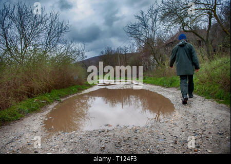 Route endommagée, fissurée épée d'asphalte avec cuvettes et les taches. Très mauvaise route asphaltée à gros trous. La construction de routes. La technologie terrible De nombreux Banque D'Images