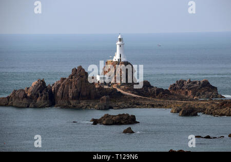 La Corbiere Lighthouse se dresse sur un éperon rocheux à marée connecté à la terre par une chaussée sur l'île de Jersey, Îles britanniques, Royaume-Uni. Banque D'Images