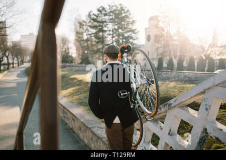 Old fashioned Bicycle Rider avec le vélo sur l'épaule Banque D'Images