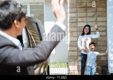 Père salué sa famille avant de se rendre au travail Banque D'Images