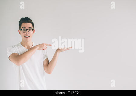 Nerd à lunettes est quelque chose dans une main imaginaire i. L'homme était sur fond blanc Banque D'Images