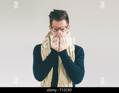 Studio photo d'un jeune homme avec un mouchoir. Guy malade a isolé le nez. l'homme fait un remède pour le rhume.Nerd est portant des lunettes. Banque D'Images