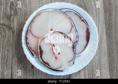 La viande de requin bleu brut sur plaque blanche sur table en bois Vue de dessus Banque D'Images