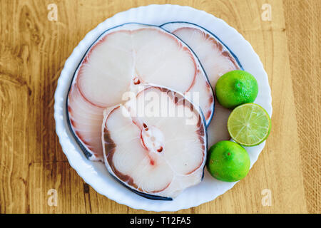 La viande de requin bleu brut et de la chaux on white plate Banque D'Images