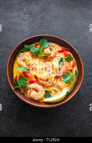 Soupe Laksa. Soupe de crevettes et nouilles laksa sur fond noir, vue du dessus, copiez l'espace. Malaise d'aliments asiatiques. Banque D'Images