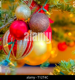 Belles boules scintillantes sur un arbre de Noël. Close up de belles boules scintillantes suspendu à la branche d'un arbre de Noël. Une chaîne de jaune Banque D'Images