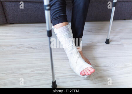 L'homme essaie de marcher avec une jambe cassée Banque D'Images