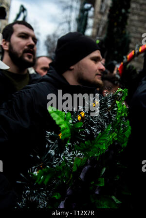 Un manifestant vu jeter des bouquets de fleurs en plastique sur les policiers en tenue de combat à l'extérieur de l'Administration présidentielle, pendant la manifestation. Les manifestants se sont réunis à la place puis ont défilé jusqu'au bâtiment de l'Administration présidentielle d'appeler Président Petro Poroshenko à apporter à la justice les responsables gouvernementaux corrompus. Avec les élections présidentielles en Ukraine qui se tiendra à la fin de mars, les tensions politiques sont très élevés. Banque D'Images