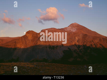 États-unis, Californie, Yosemite National Park, la pleine lune se lève sur le Mont Dana au coucher du soleil ; près de Tioga Pass. Banque D'Images