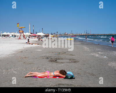 Une femme dans un bikini de soleil sur la plage de Constanta. Banque D'Images