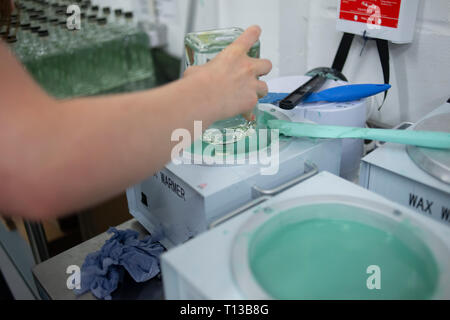 Trempant une bouteille de gin dans la cire chaude pour le fermer Banque D'Images