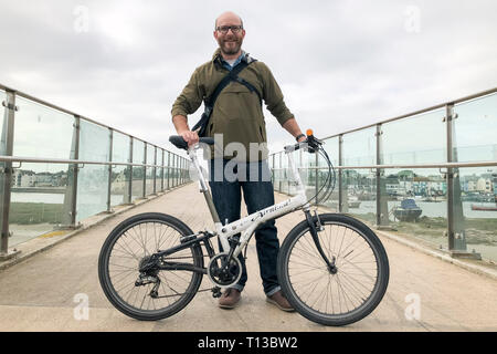 Un homme blanc se dresse sur l'Adur Shoreham Ferry Bridge avec un vélo pliant Banque D'Images