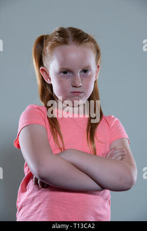 Une fille aux cheveux rouges avec ses bras croisés. Banque D'Images
