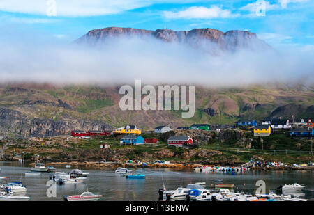 Brouillard épais sur l'île avec des maisons peintes de couleurs vives et de port, Qeqertarsuaq, Groenland Banque D'Images