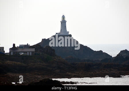 La Corbiere Lighthouse se dresse sur un éperon rocheux à marée connecté à la terre par une chaussée sur l'île de Jersey, Îles britanniques, Royaume-Uni. Banque D'Images