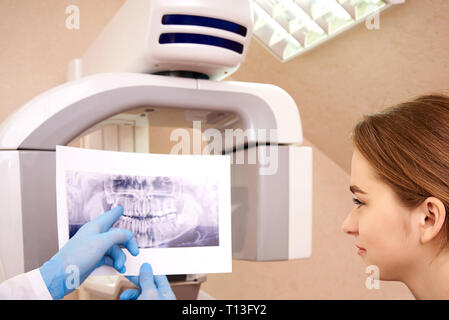 Dentist showing x-ray à son patient en clinic.Computed dentaires tomographie par ordinateur dans la dentisterie. Banque D'Images