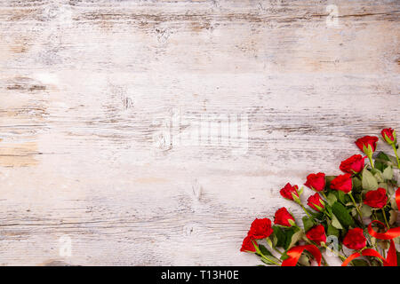 Roses rouges sur la table en bois blanc, pour une fête des mères Banque D'Images