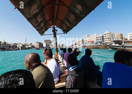 Dubaï, Émirats arabes unis - Mars 2019 : personnes à bord de l'eau en bois traditionnels bateaux taxi à Dubaï Creek Banque D'Images