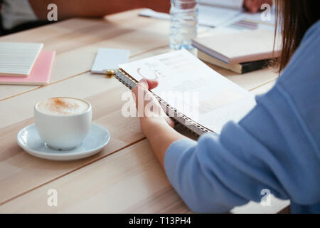 Femme travaillant sur papier at desk in office Banque D'Images