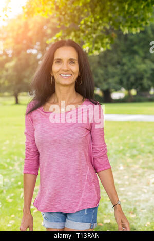 Portrait de femme mature détendue dans un parc en été Banque D'Images