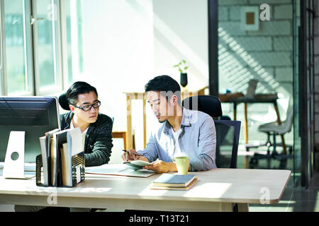 Deux jeunes dirigeants de sociétés asiatiques travaillant ensemble discuter de plan d'affaires de l'office. Banque D'Images