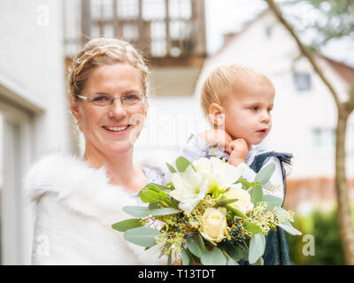 Portrait of happy bride avec petite fille et bouquet de mariée Banque D'Images