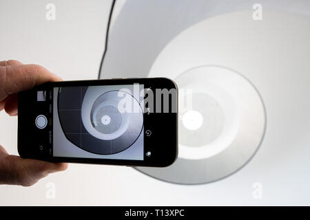 23 mars 2019, la Bavière, Nuremberg : ILLUSTRATION - photographies d'un homme avec un téléphone mobile dans l'escalier de l'escalier en spirale dans le Neues Museum Nürnberg. La liquidation d'escalier noir et blanc moderne, rappelant une coquille d'escargot, est un motif particulièrement populaire pour le réseau social Instagram. Avec d'innombrables images et vidéos de beaux endroits dans le monde, Instagram est l'un des plus populaires des réseaux sociaux. Certains endroits bénéficient de l'attention qu'ils y arrivent, d'autres souffrent et veulent tirer le cordon. (Dpa-Korr : 'Malédiction ou bénédiction ? Comment Bavaria traite de l'Instagram pilgri Banque D'Images