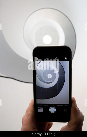 23 mars 2019, la Bavière, Nuremberg : ILLUSTRATION - photographies d'un homme avec un téléphone mobile dans l'escalier de l'escalier en spirale dans le Neues Museum Nürnberg. La liquidation d'escalier noir et blanc moderne, rappelant une coquille d'escargot, est un motif particulièrement populaire pour le réseau social Instagram. Avec d'innombrables images et vidéos de beaux endroits dans le monde, Instagram est l'un des plus populaires des réseaux sociaux. Certains endroits bénéficient de l'attention qu'ils y arrivent, d'autres souffrent et veulent tirer le cordon. (Dpa-Korr : 'Malédiction ou bénédiction ? Comment Bavaria traite de l'Instagram pilgri Banque D'Images