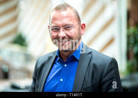 Langenhagen, Allemagne. Mar 23, 2019. Frank Werneke, vice-président du syndicat Verdi, se dresse dans le hall d'un hôtel du congrès. Les délégués de l'état de Verdi District de Basse-Saxe et Brême pour répondre à l'état bas Saxony-Bremen Conférence de District. Credit : Hauke-Christian Dittrich/dpa/Alamy Live News Banque D'Images