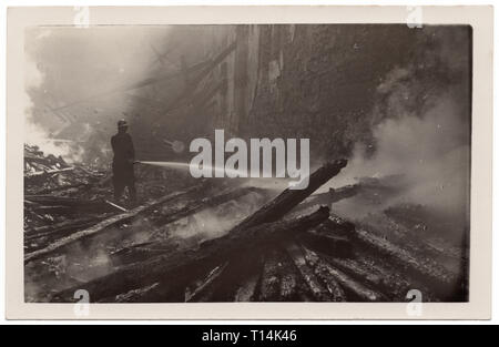 Fireman utilise un canon à eau pour combattre le feu à l'intérieur d'un bâtiment non identifié détruit lors de l'Insurrection de Prague dans les derniers jours de la Seconde Guerre mondiale en mai 1945 à Prague, Tchécoslovaquie. Probablement les ruines de l'aile néo-gothique de l'Ancien hôtel de ville (radnice Staroměstská) à la place de la vieille ville (Staroměstské náměstí) à Prague. Vintage noir et blanc photographie par un photographe inconnu prise en mai 1945. Avec la permission de l'Azoor Photo Collection. Banque D'Images