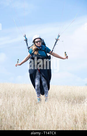 Une jeune femme para planeur décolle de la South Downs. Banque D'Images