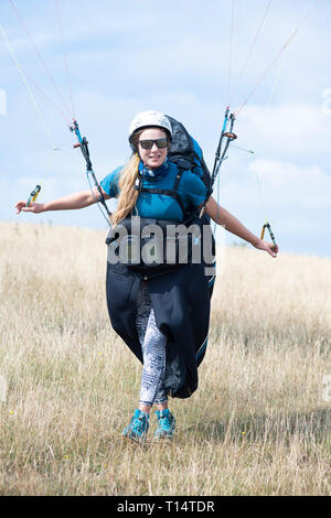 Une jeune femme para planeur décolle de la South Downs. Banque D'Images