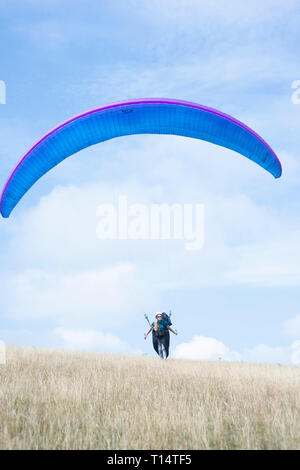 Une jeune femme para planeur décolle de la South Downs. Banque D'Images