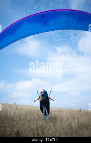 Une jeune femme para planeur décolle de la South Downs. Banque D'Images