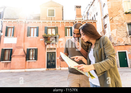 L'Italie, Venise, young couple looking at map dans la ville Banque D'Images