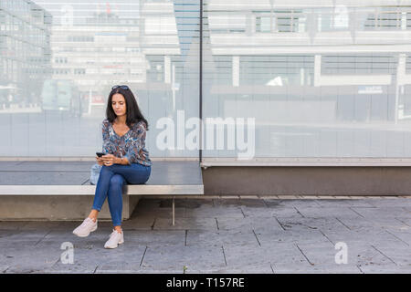 Mature Woman using smartphone outdoors Banque D'Images