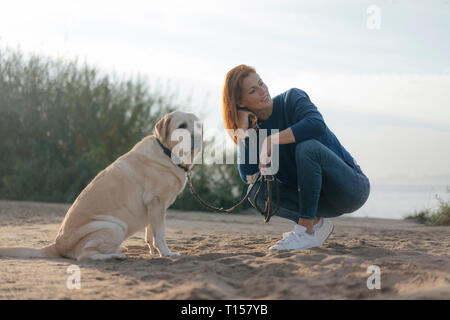 Allemagne, Hambourg, femme avec chien sur la plage au bord de l'Elbe Banque D'Images